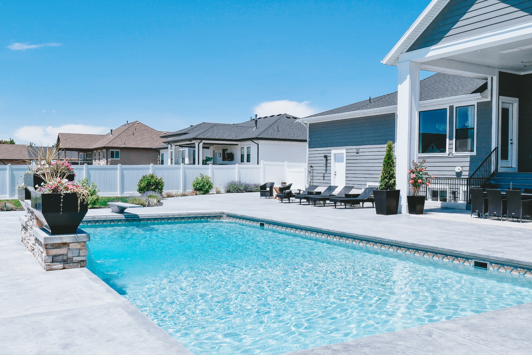 Farmington Utah Vinyl Pool & Stamped Concrete Patio — Barr Pool Builders Custom vinyl inground swimming pool with stamped concrete patio, diving board and outdoor dining in Farmington, Utah by Barr Pool Builders